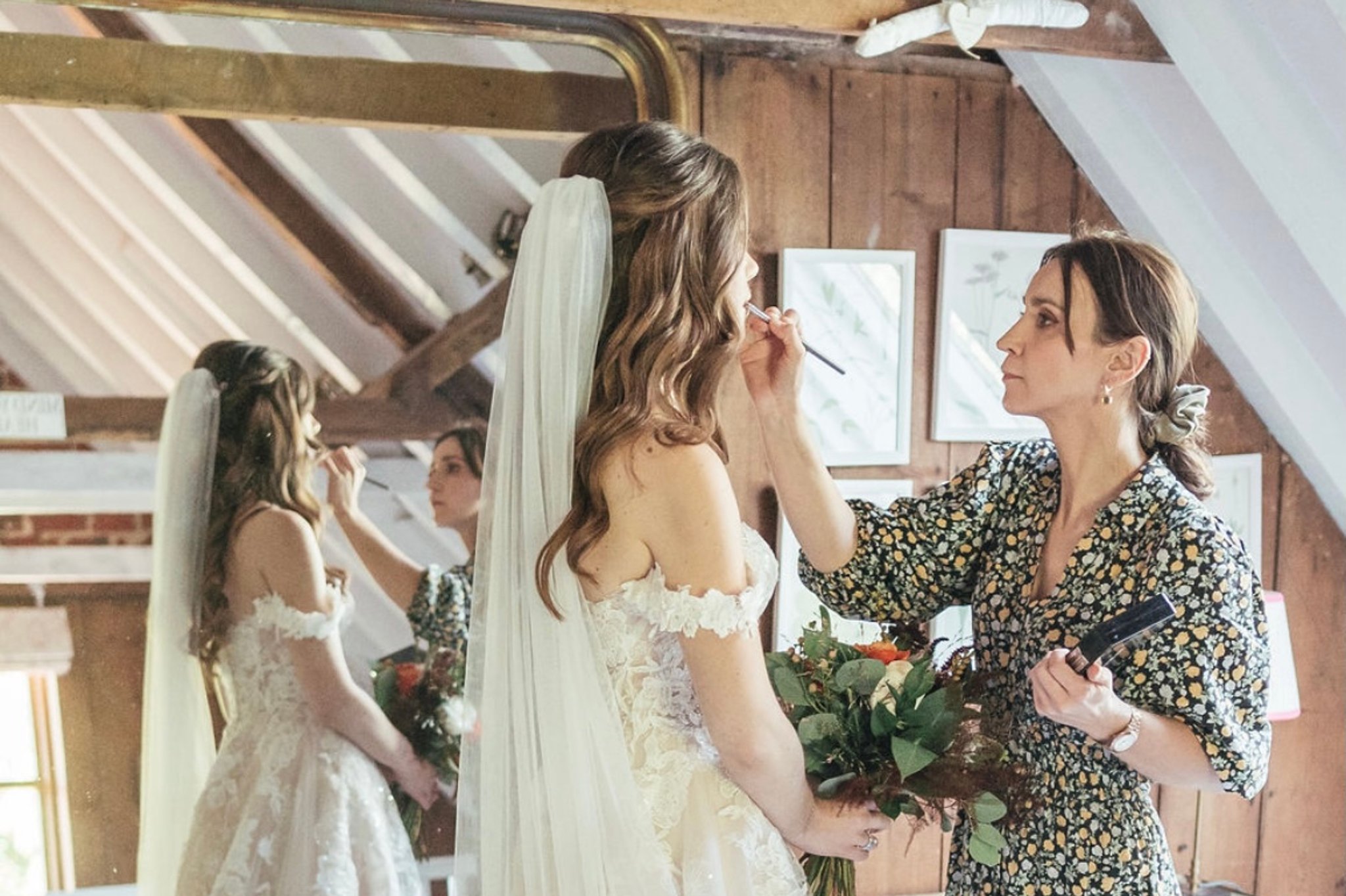 Bride having her makeup touched up by a makeup artist