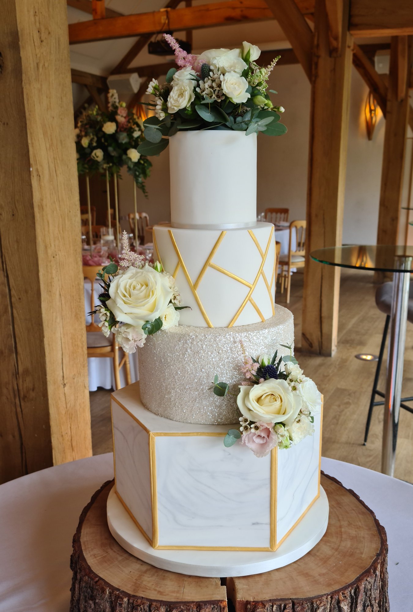 Four tiered geometric gold and cream wedding cake with marble effect icing and glitter 