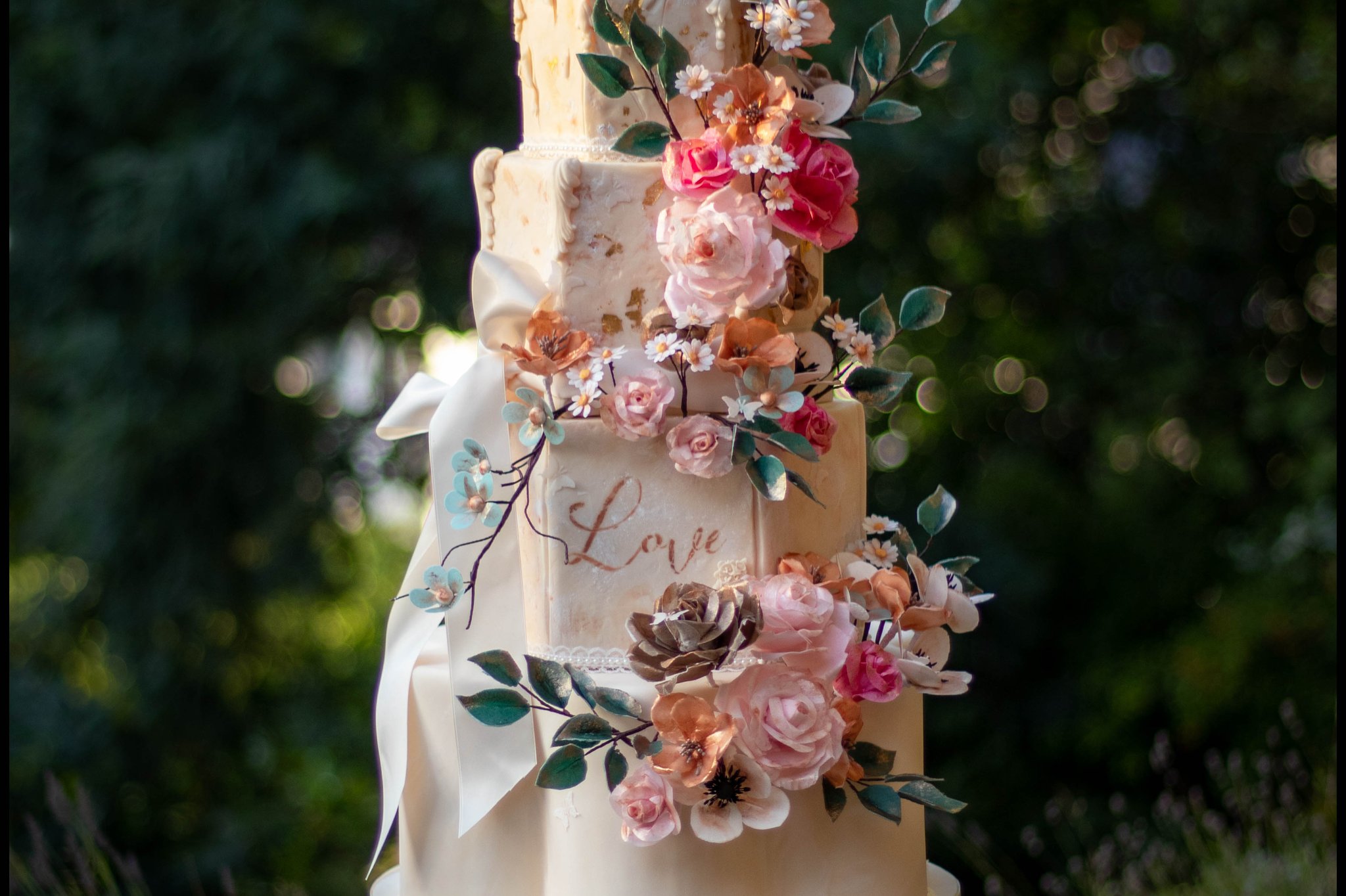 Four tiered wedding cake decorated with flowers