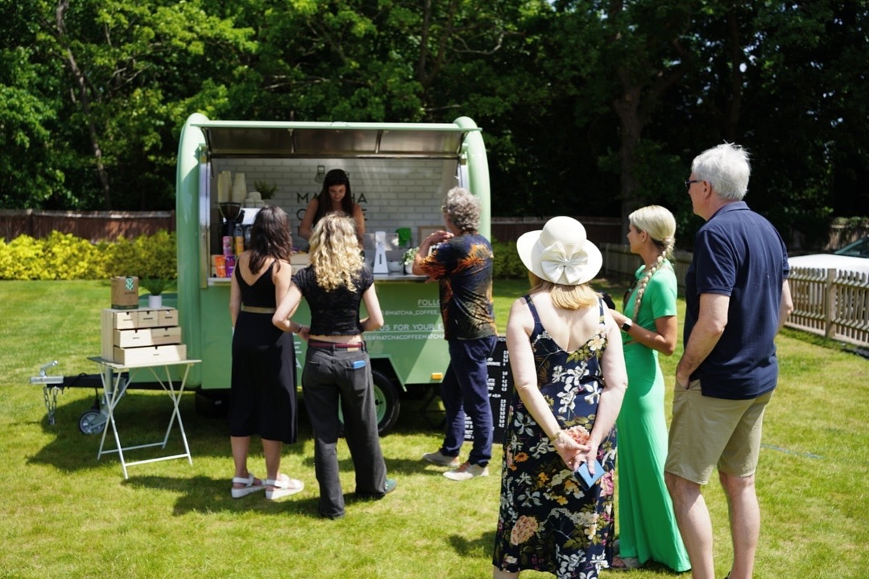 a queue of wedding guests waiting at a matcha station in the garden