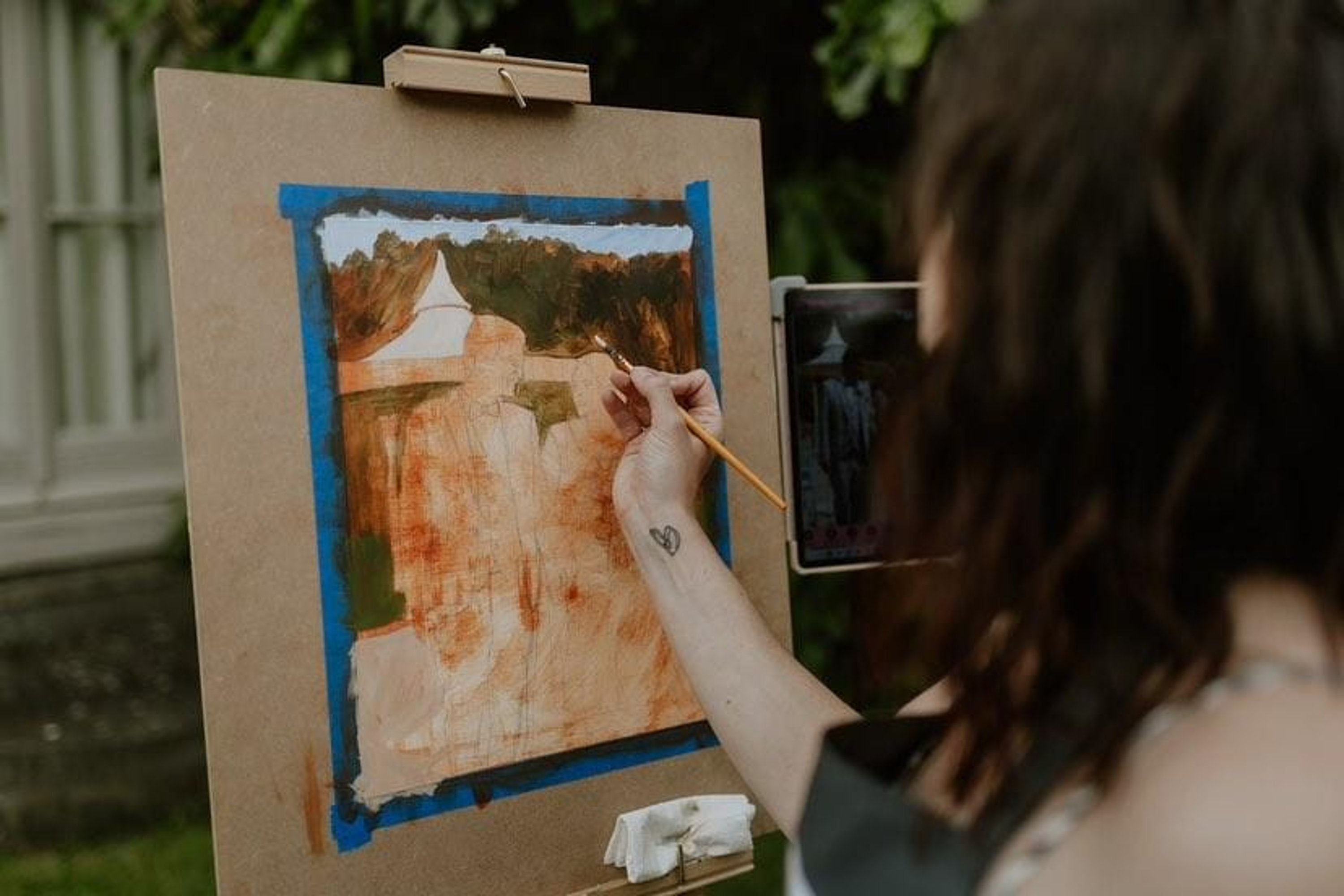 live wedding artist painting a newly married couple in watercolour outdoors