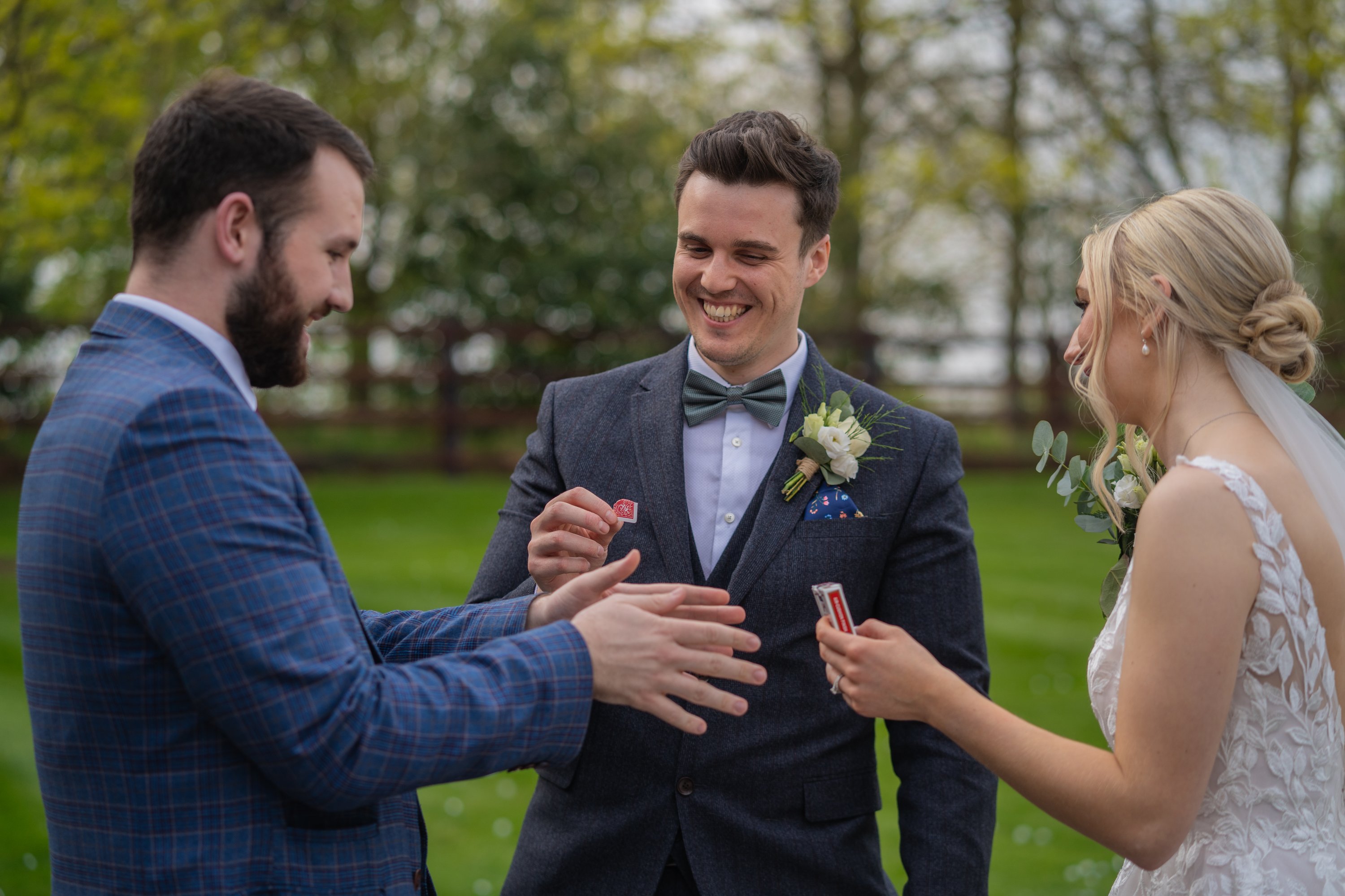 a wedding magician entertaining a newly married bride and groom at their wedding with a card trick