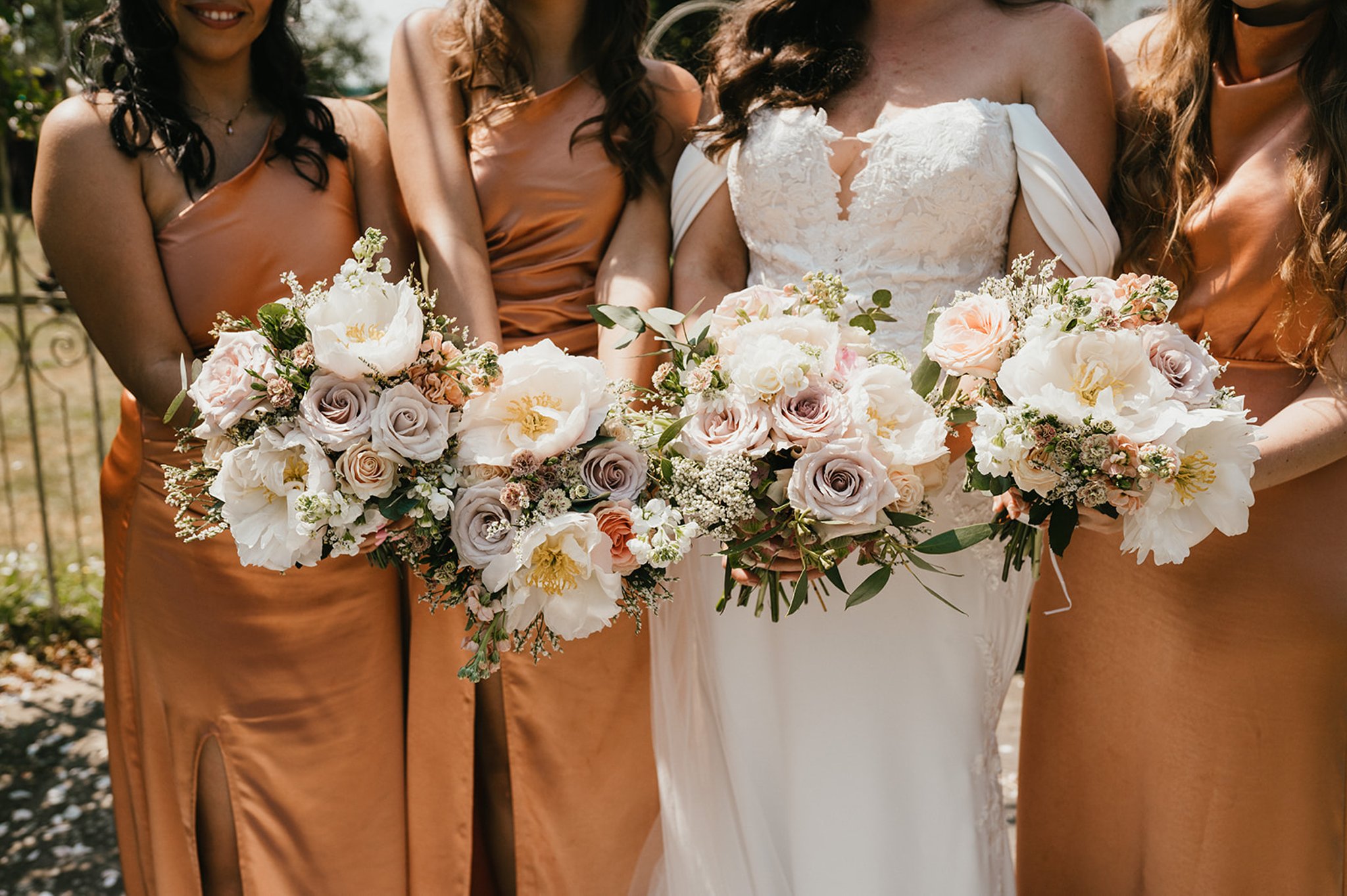 Bridesmaids and bride showing off their wedding flowers