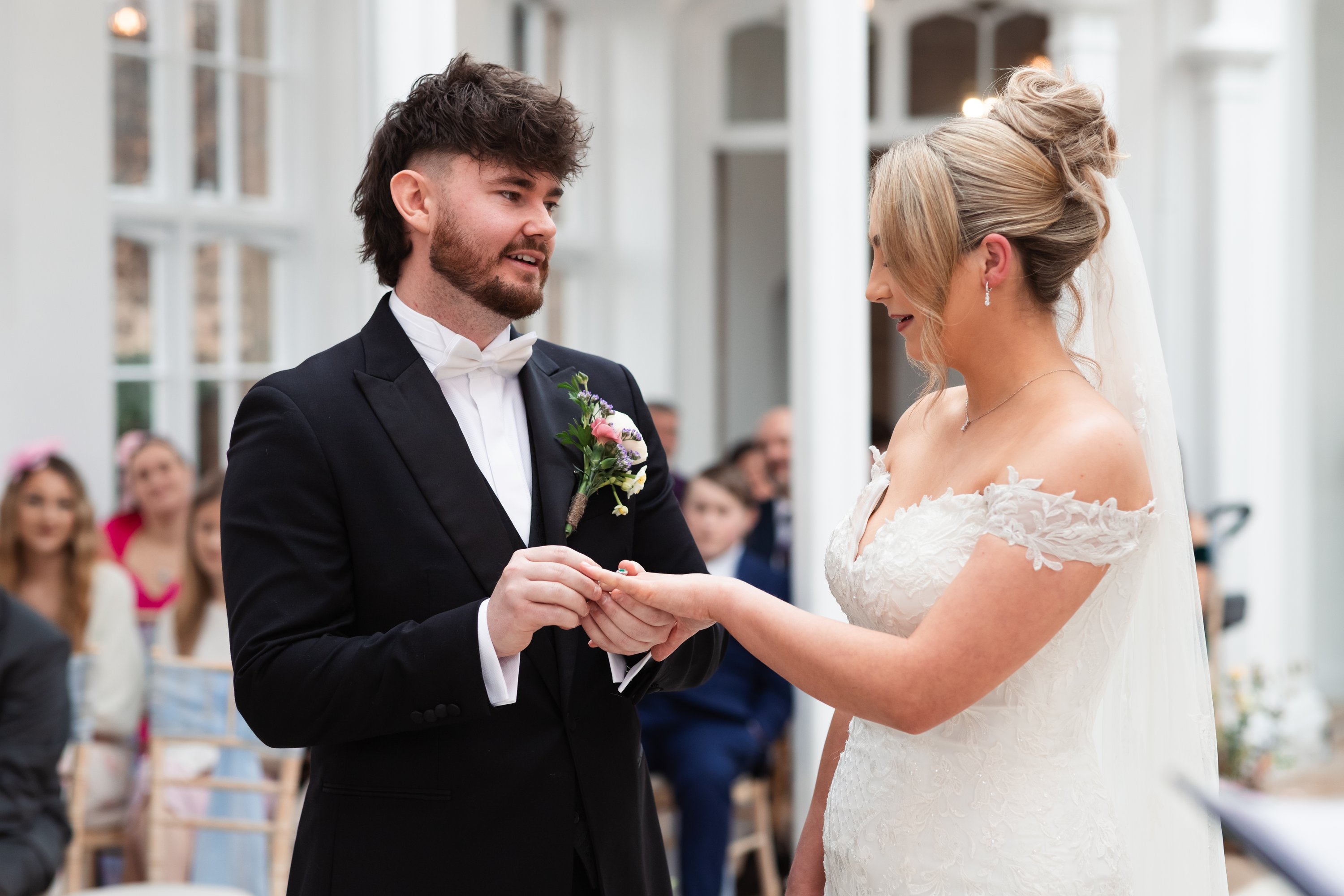 groom putting the ring on his new bride, saying his vows during the ceremony