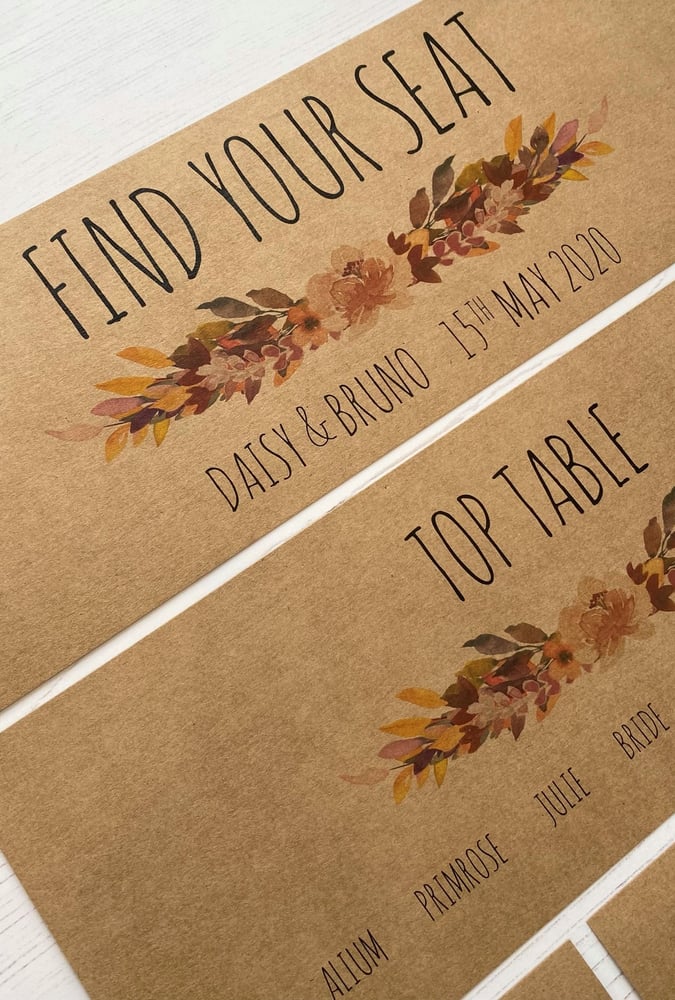 a cardboard autumn themed welcome wedding sign on brown paper with leaf motif