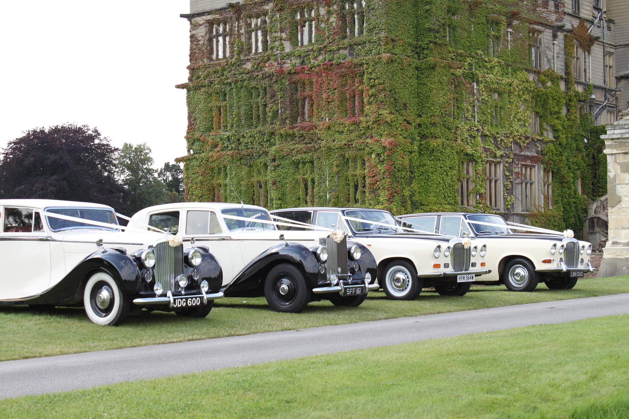 Fleet of vintage wedding cars outside of a wedding venue