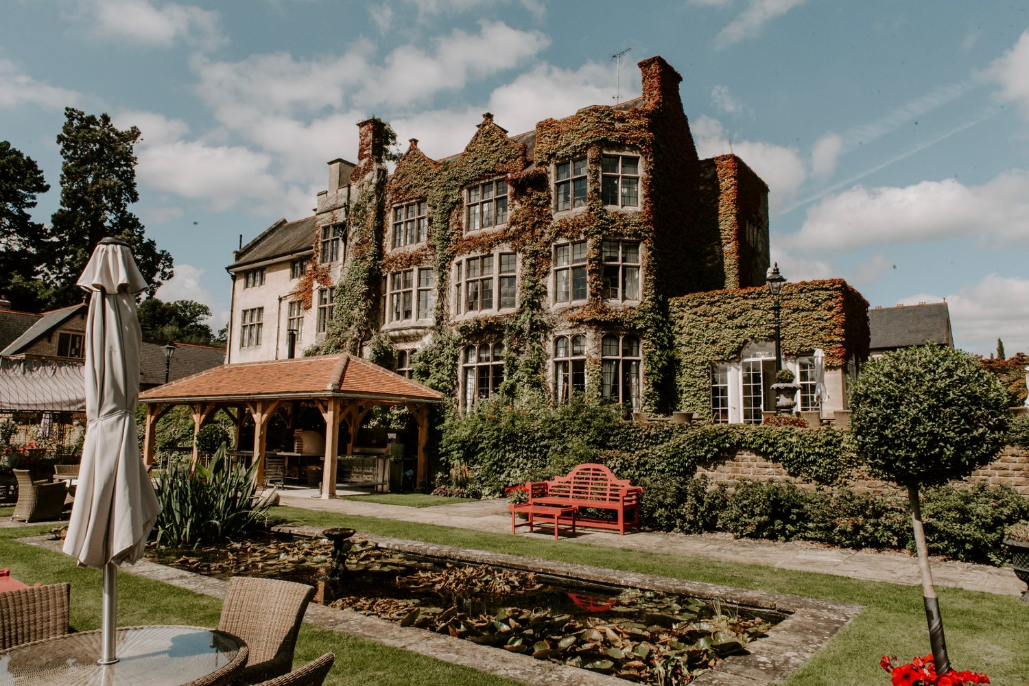 exterior of wedding venue with grand windows and greenery growing on the walls 