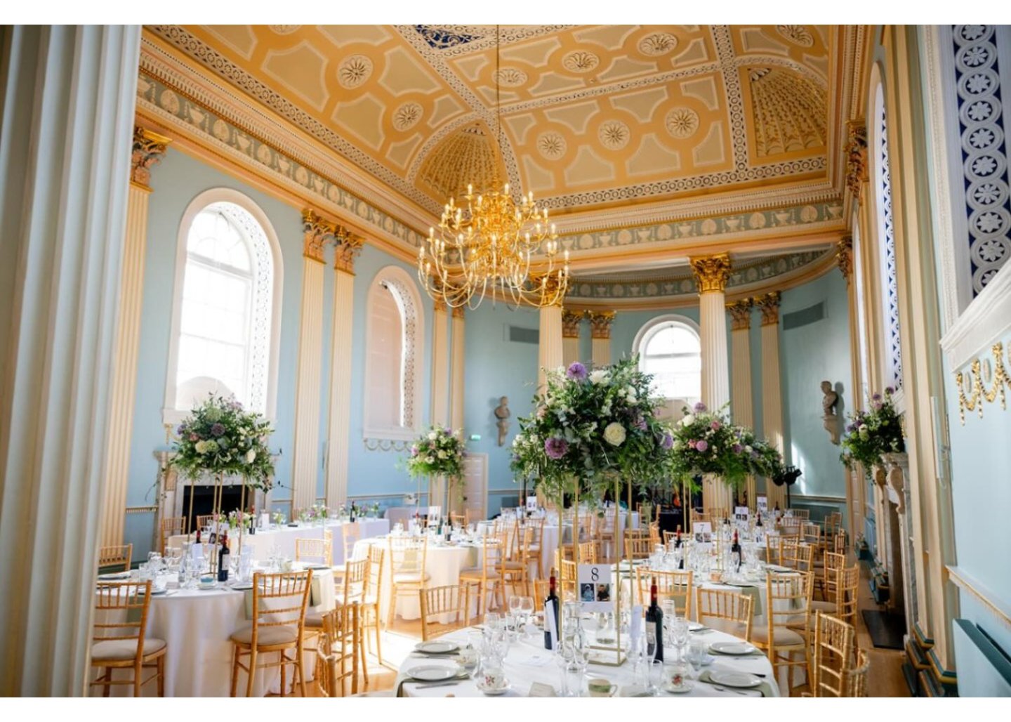 A blue and gold reception room in Newark Town Hall with a chandelier and fresh greenery and flowers