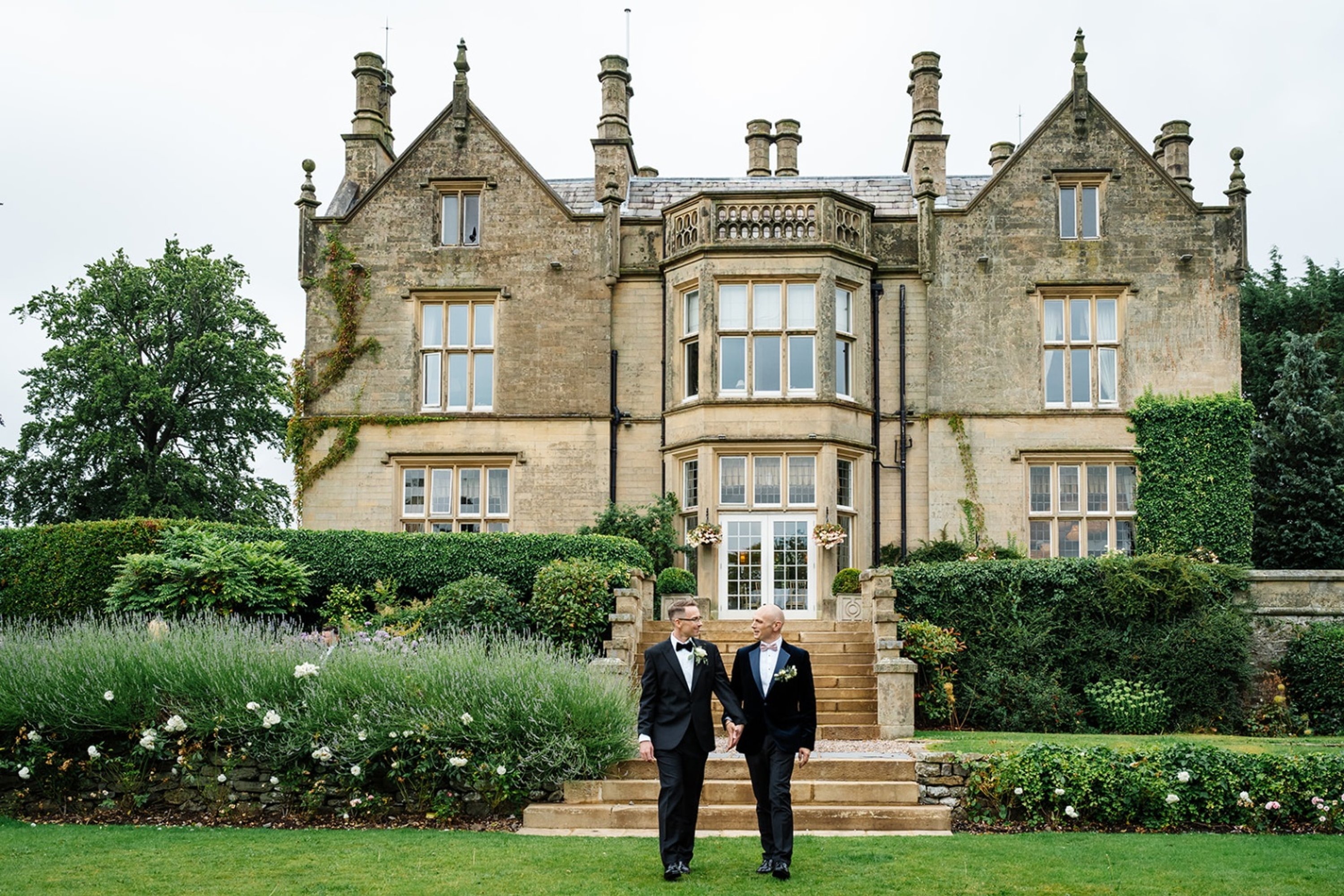 LGBTQ+ couple standing in front of the wedding venue