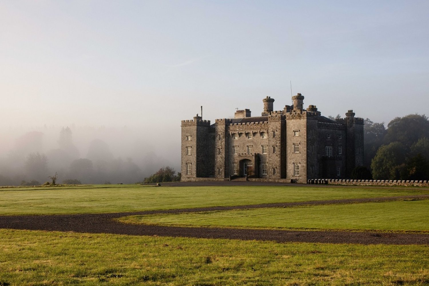 a castle surrounded by open space and fog 