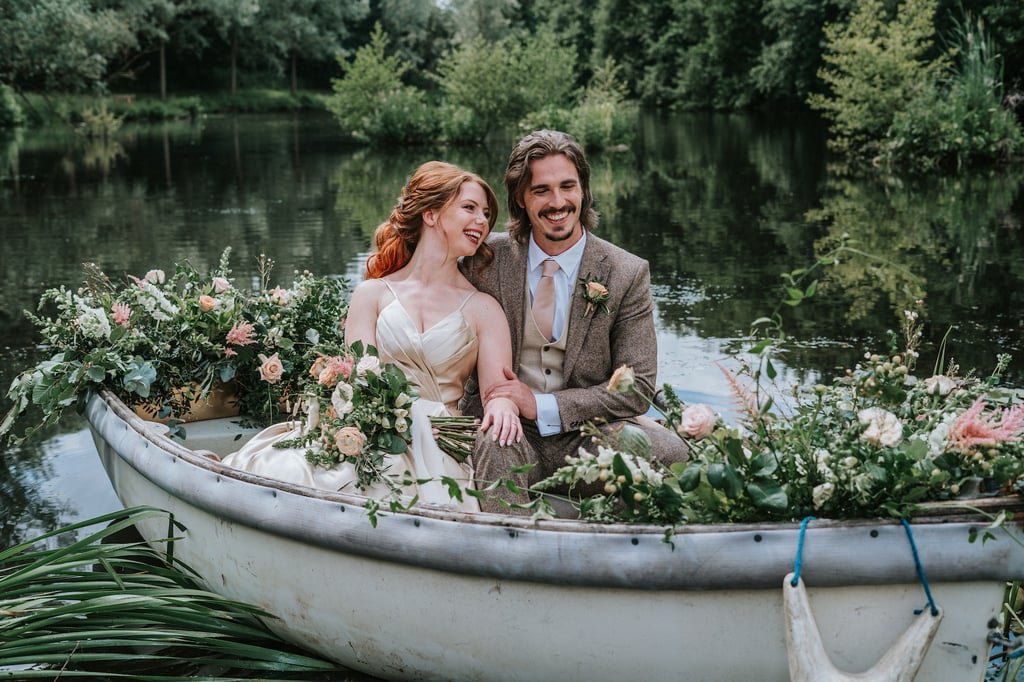 A bride and groom in a floral adorned rowing boat