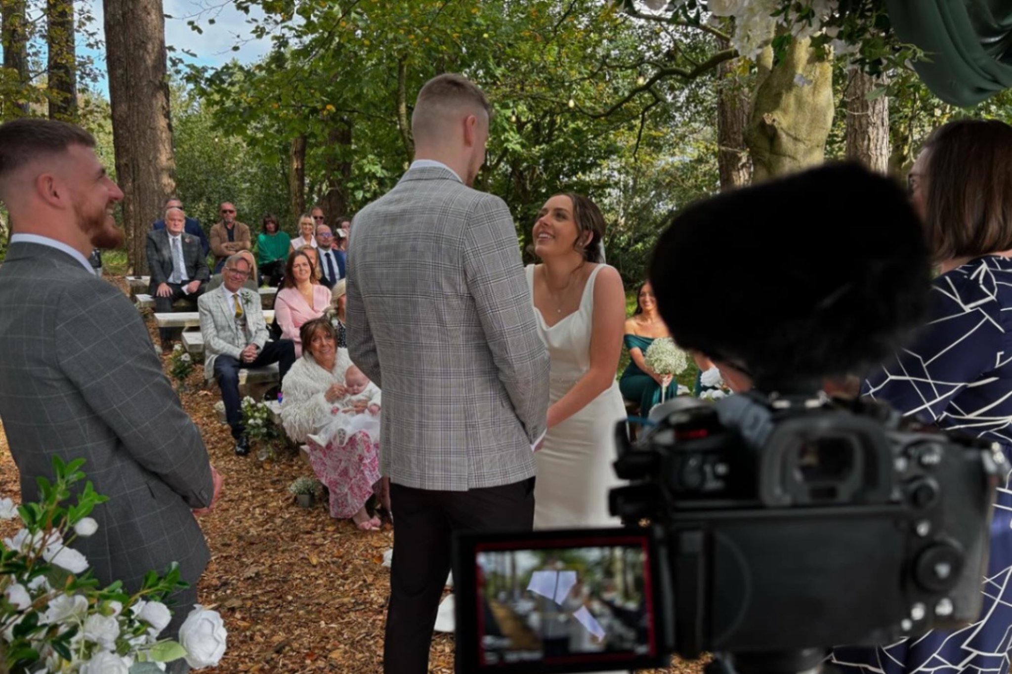 Bride and groom being filmed by a videographer during their wedding ceremony